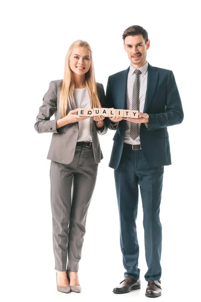 Empresarios sonrientes con trajes que sostienen cubos de alfabeto con palabra de igualdad, aislados en blanco - foto de stock