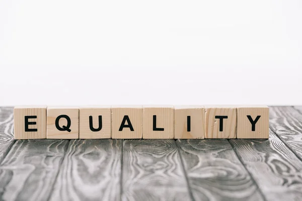 Alphabet cubes with equality word on wooden table on white — Stock Photo