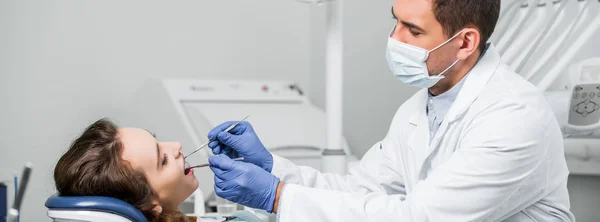 Dentist in mask and latex gloves examining teeth of woman in dental clinic — Stock Photo