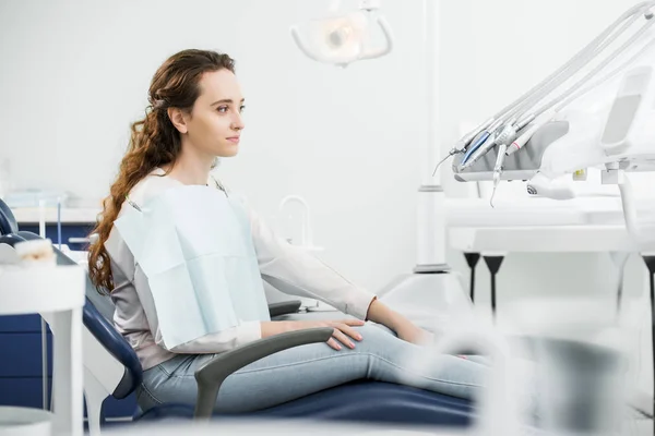 Cheerful woman smiling while sitting on chair in dental clinic — Stock Photo