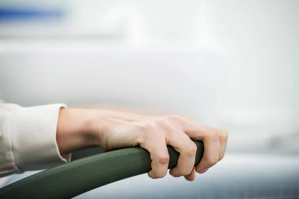 Vue recadrée de femme tenant la poignée de chaise dans la clinique dentaire — Photo de stock