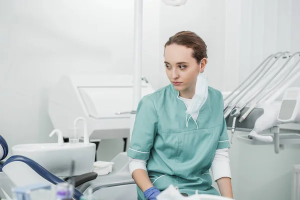 Selective socus of thoughtful female dentist sitting in dental clinic — Stock Photo