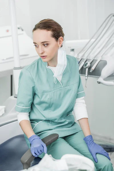 Selective socus of sad female dentist sitting in dental clinic — Stock Photo