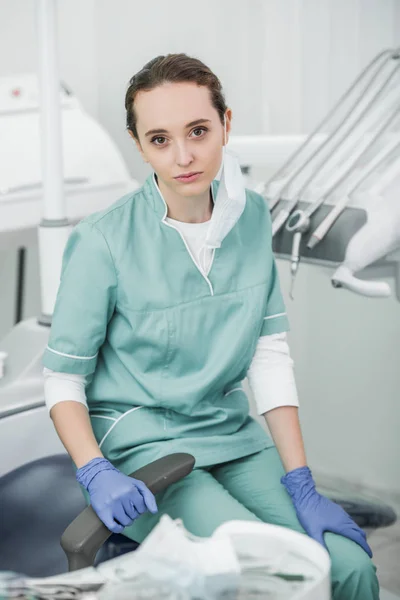 Socus selectivo del dentista femenino molesto sentado en la clínica dental - foto de stock