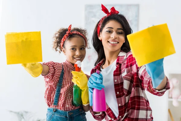 Sorridente afro americano madre e dauhgter pulizia casa con stracci gialli — Foto stock