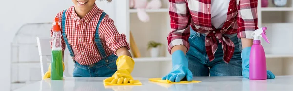 Vue recadrée de la mère afro-américaine avec sa fille table de nettoyage en gants en caoutchouc brillant — Photo de stock