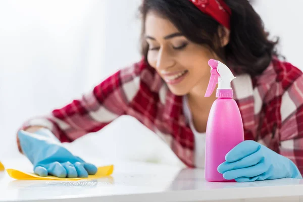 Selective focus of smiling african american woman cleaning table — Stock Photo