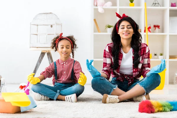 African american mother with cute daughter sitting in lotus pose — Stock Photo