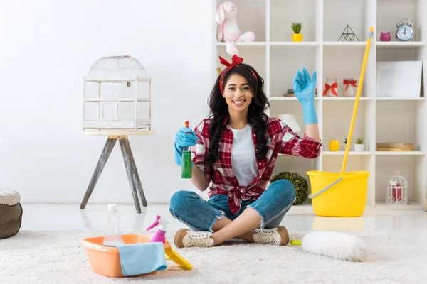 Cheerful african american woman in plaid shirt sitting in lotus pose and showing ok sign — Stock Photo