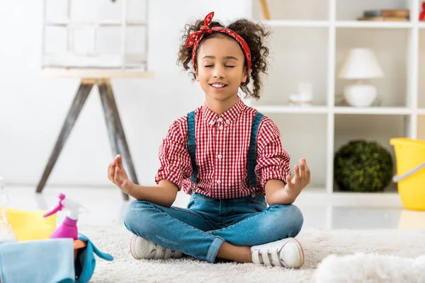 Adorable african american child sitting in lotus pose with closed eyes — Stock Photo