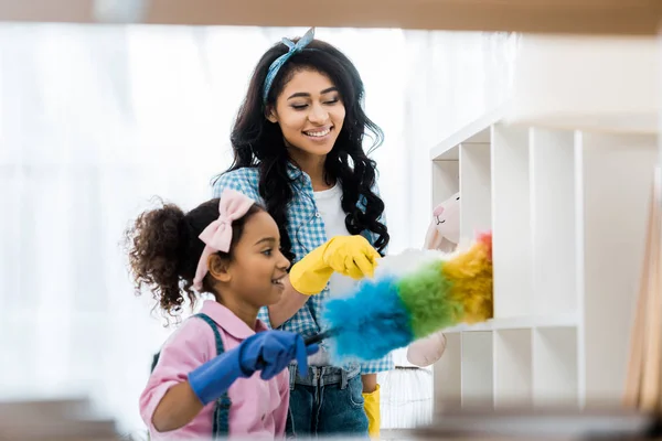 Pretty african american woman with daughter cleaning house — Stock Photo