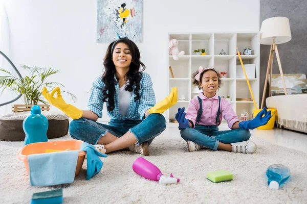 Glückliche afrikanisch-amerikanische Mutter und Tochter auf Teppich sitzend in Lotus-Posen mit geschlossenen Augen — Stockfoto