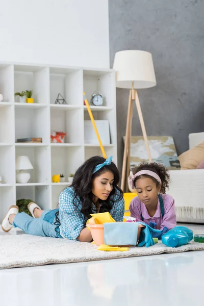 Müde afrikanisch-amerikanische Mutter und Tochter ruhen auf Teppich — Stockfoto