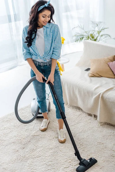 Schöne afrikanisch-amerikanische Frau putzt Teppich mit Staubsauger — Stockfoto