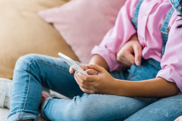 Vue recadrée de la mère afro-américaine et sa fille en utilisant smartphone ensemble — Photo de stock