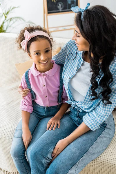 Glücklich afrikanisch-amerikanische Mutter umarmt entzückende Tochter — Stockfoto