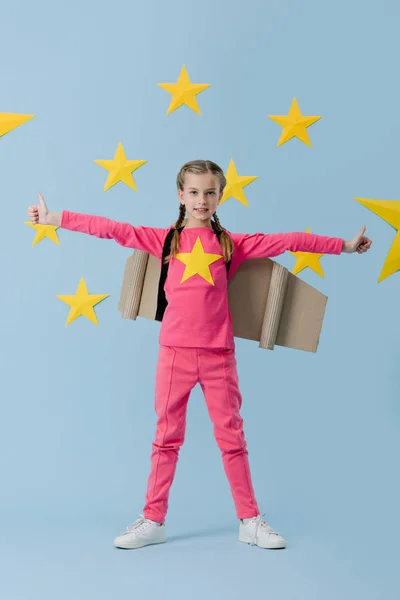 Kid with braids showing thumbs up on blue starry background — Stock Photo