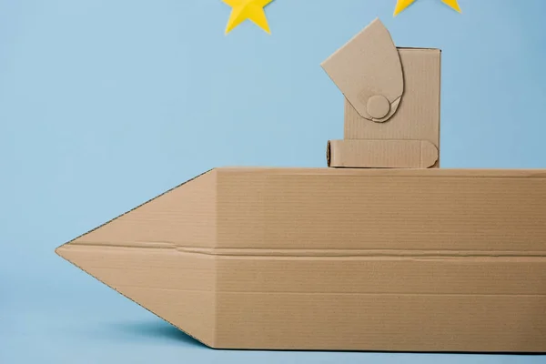 Cardboard rocket and helmet on blue background — Stock Photo