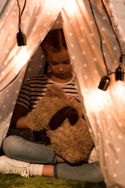 Frühchen spielt mit Teddybart in Perücke mit Glühbirnen — Stockfoto