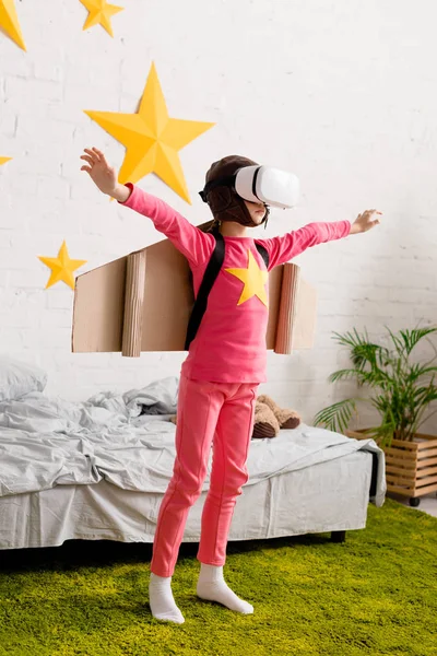 Full length view of kid in vr headset waving hands in bedroom — Stock Photo