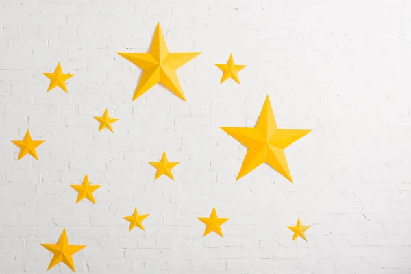 Estrelas de papelão amarelo em fundo texturizado claro — Fotografia de Stock