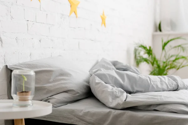 Accogliente camera da letto luminosa con letto e piante verdi — Foto stock