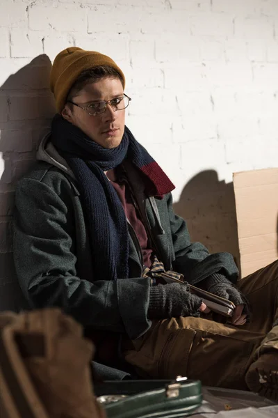 Homem sem-teto em óculos sentado em lixeira — Fotografia de Stock