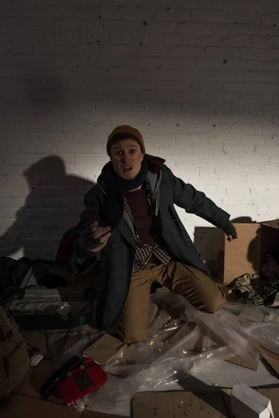 Drunk angry homeless man standing on knees on rubbish dump — Stock Photo