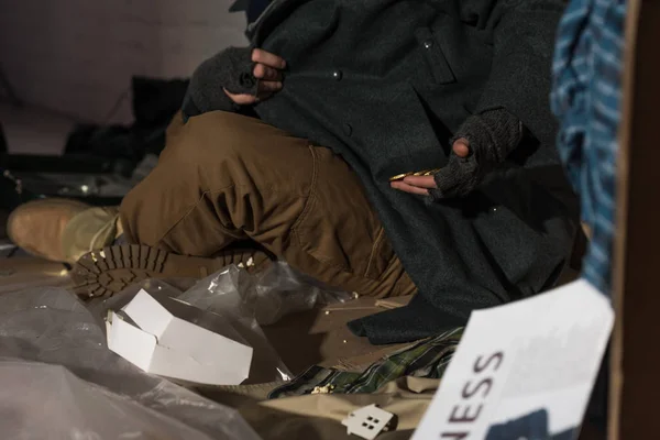 Vue partielle de sans-abri mendiant homme sortir des pièces de monnaie de poche — Photo de stock