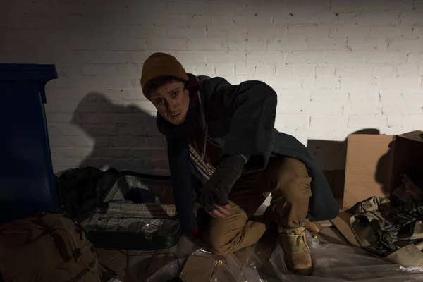 Drunk angry homeless man standing on knee on rubbish dump — Stock Photo