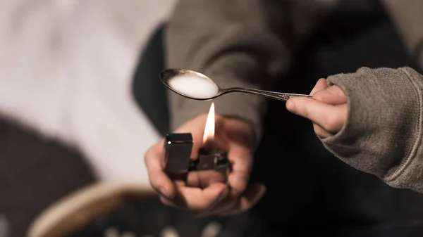 Foco seletivo do viciado homem fervendo heroína na colher no isqueiro — Fotografia de Stock