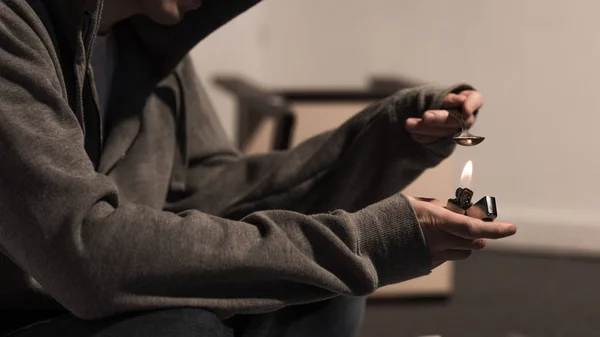Visão parcial do homem narcomaníaco colher fervente com heroína no isqueiro — Fotografia de Stock