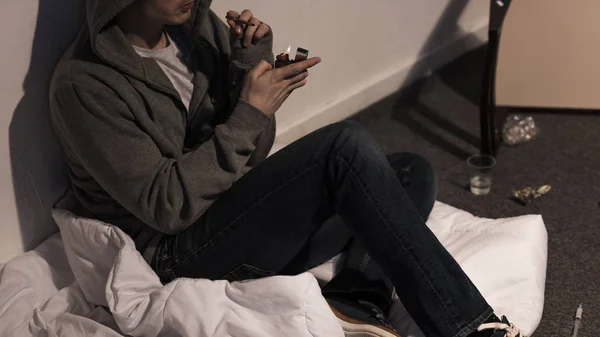 Junkie man holding marijuana rolled cigarette and lighter — Stock Photo