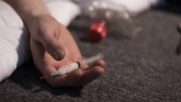 Selective focus of male hand with heroin dose in syringe — Stock Photo