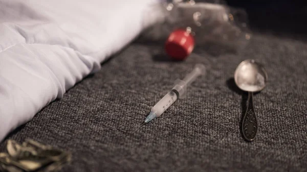 Selective focus of syringe and spoon with heroin on floor — Stock Photo