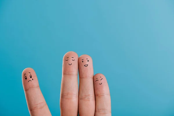Cropped view of happy fingers with one sad isolated on blue — Stock Photo