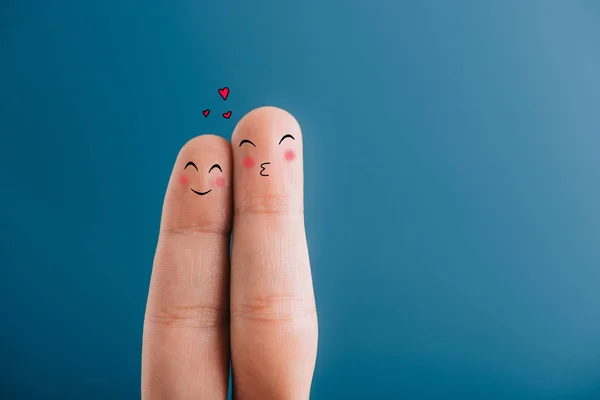 Vue recadrée du couple souriant de doigts avec des cœurs isolés sur bleu — Photo de stock