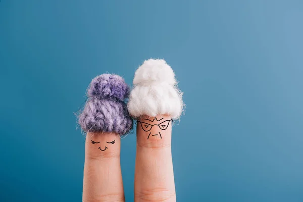 Vue recadrée des doigts comme de vieilles femmes en bonnets tricotés isolés sur bleu — Photo de stock