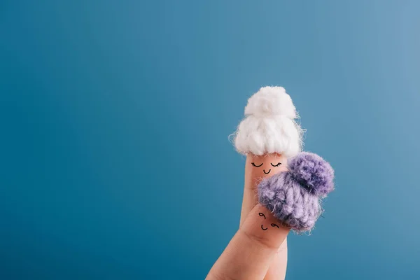 Cropped view of fingers as dreamy women in knitted hats isolated on blue — Stock Photo