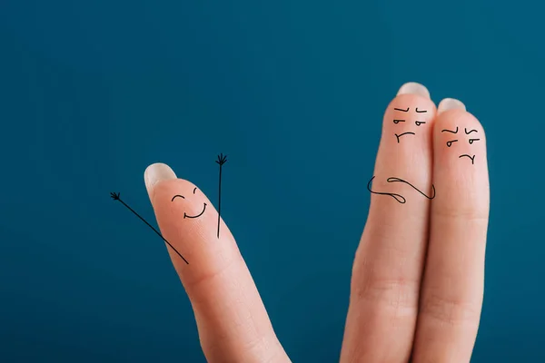 Cropped view of fingers in bad mood looking at one happy finger isolated on blue — Stock Photo