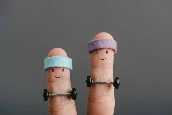 Vista recortada de sonrientes dedos deportivos en diademas de entrenamiento con barras aisladas en gris - foto de stock