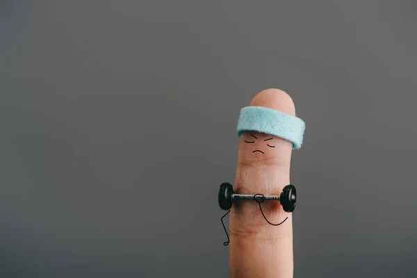 Cropped view of finger as sportsman in headband exercising with barbell isolated on grey — Stock Photo