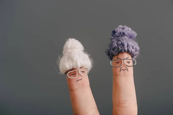 Vue recadrée des doigts comme de vieilles femmes insatisfaites dans des lunettes et des chapeaux tricotés isolés sur gris — Photo de stock