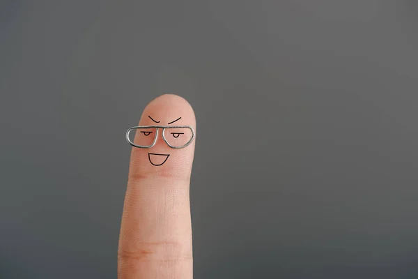 Vista recortada de un dedo alegre en gafas aisladas en gris - foto de stock