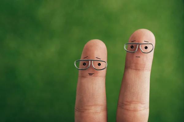 Обрізаний вид людських пальців в окулярах на зеленому — стокове фото