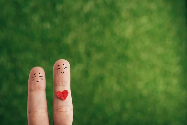 Vue recadrée de couple heureux de doigts avec coeur pour la Saint-Valentin sur vert — Photo de stock