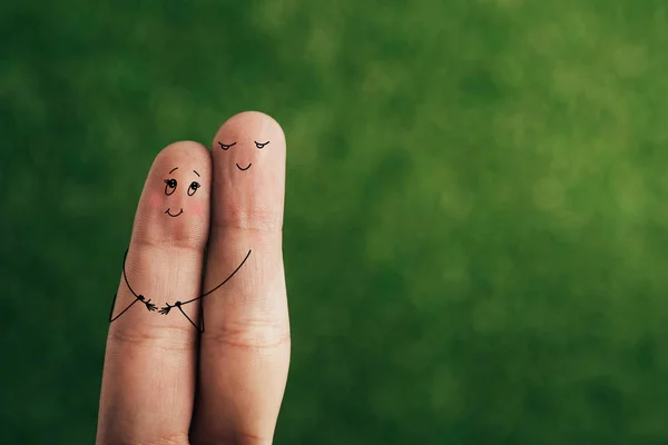 Cropped view of happy couple of fingers hugging on green — Stock Photo