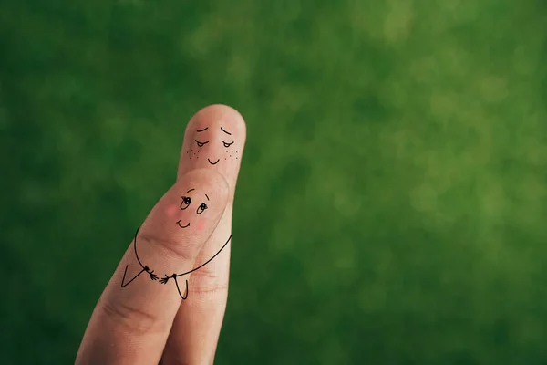 Cropped view of smiling couple of fingers embracing on green — Stock Photo