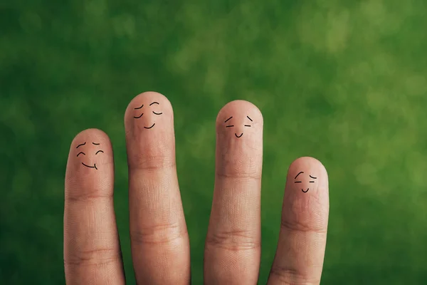 Partial view of happy human fingers on green — Stock Photo