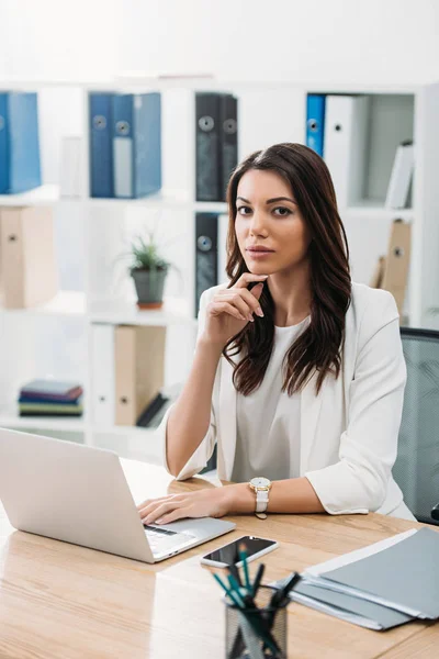 Бізнес-леді сидить за столом з ноутбуком в офісі — стокове фото